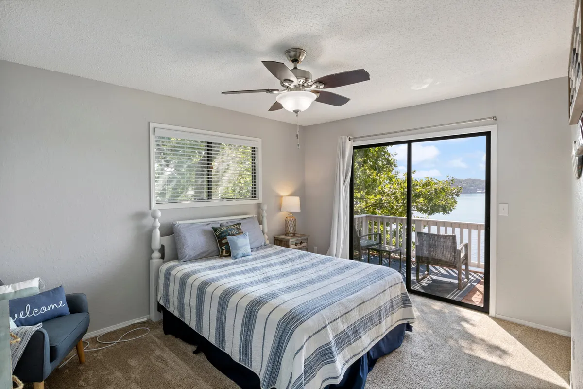 A serene bedroom with a comfortable bed placed near a window, a cozy chair, and a lamp. The window offers a tranquil view of the outdoors, flooding the room with natural light and inviting the peaceful ambiance inside.